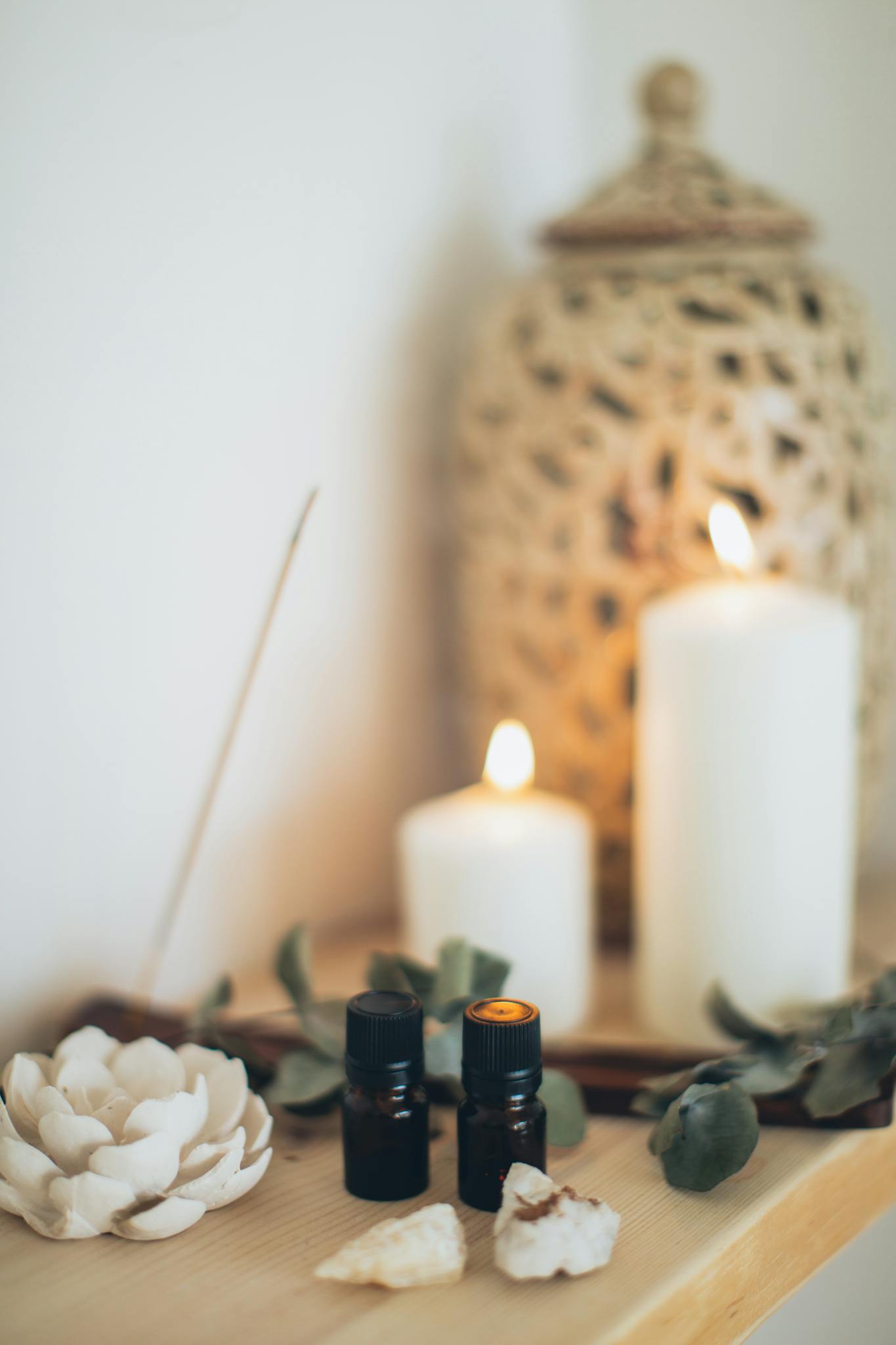 Tranquil scene featuring essential oils, candles, and eucalyptus for a relaxing atmosphere.